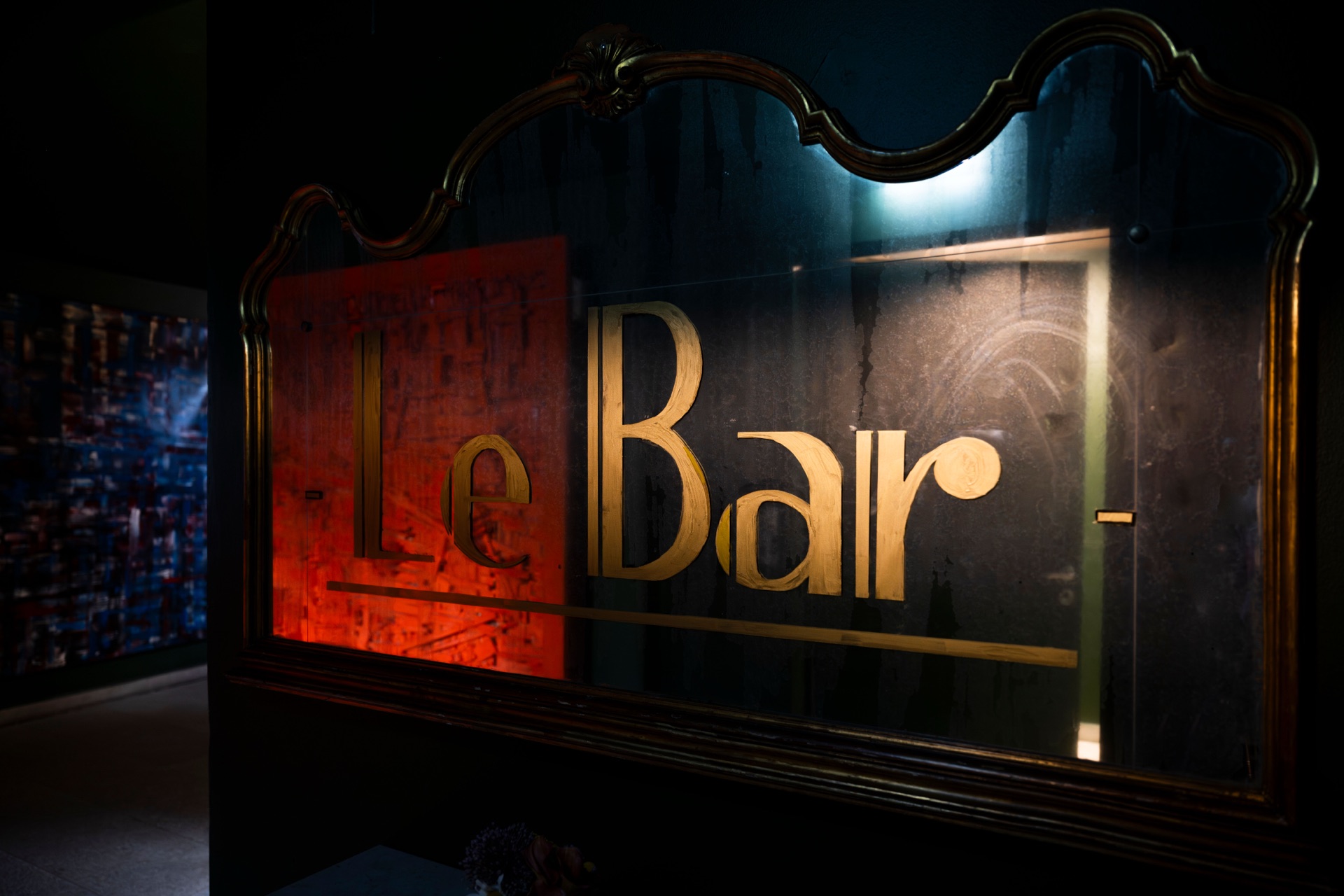 The gilded 'Le Bar' sign etched into the mirror at the entrance