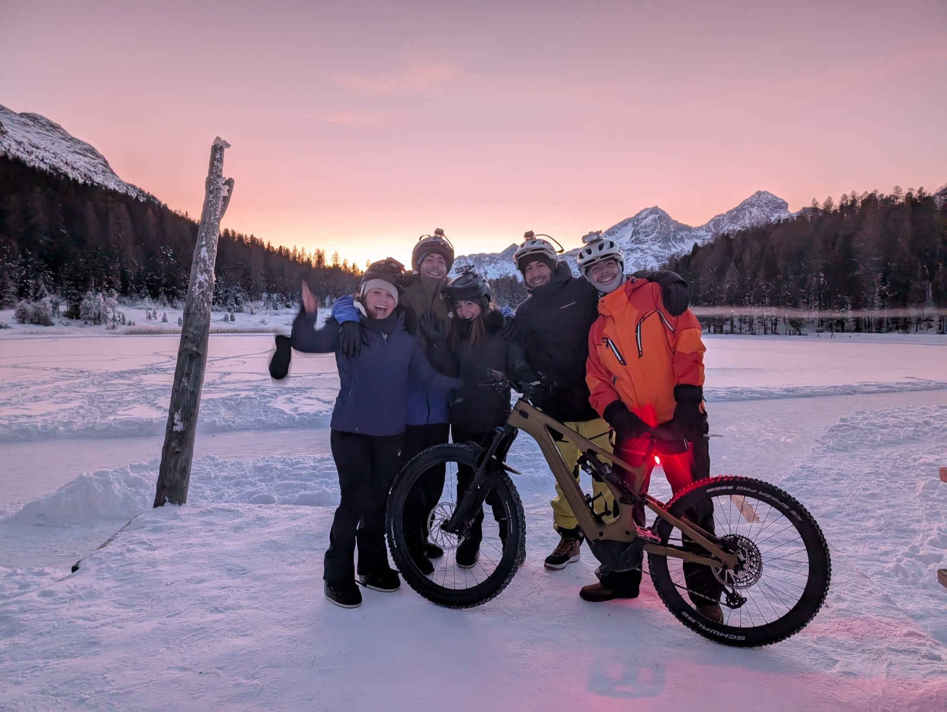 A group watching the sun set over the frozen lake
